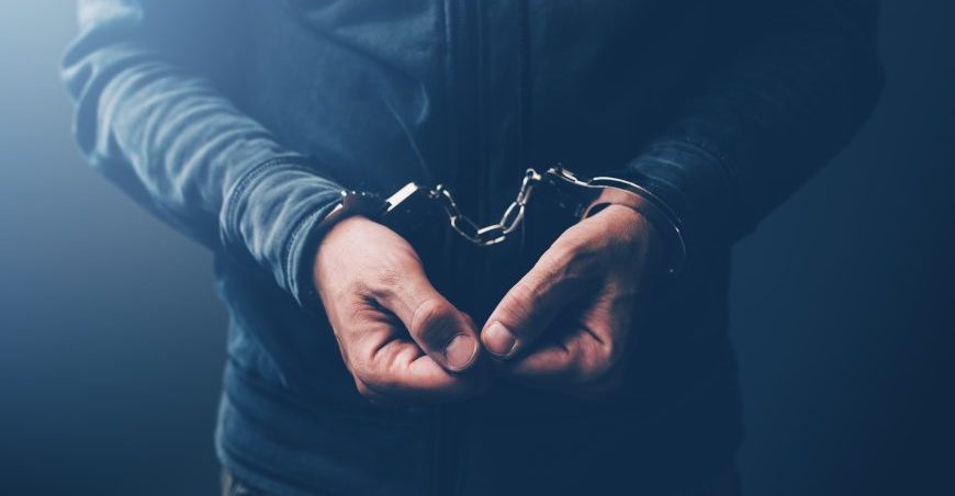 Arrested computer hacker with handcuffs