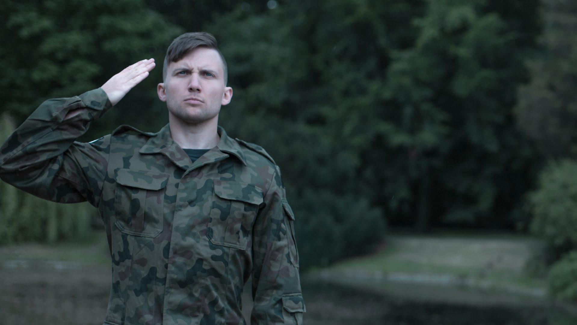 Ssoldier wearing military uniform saluting