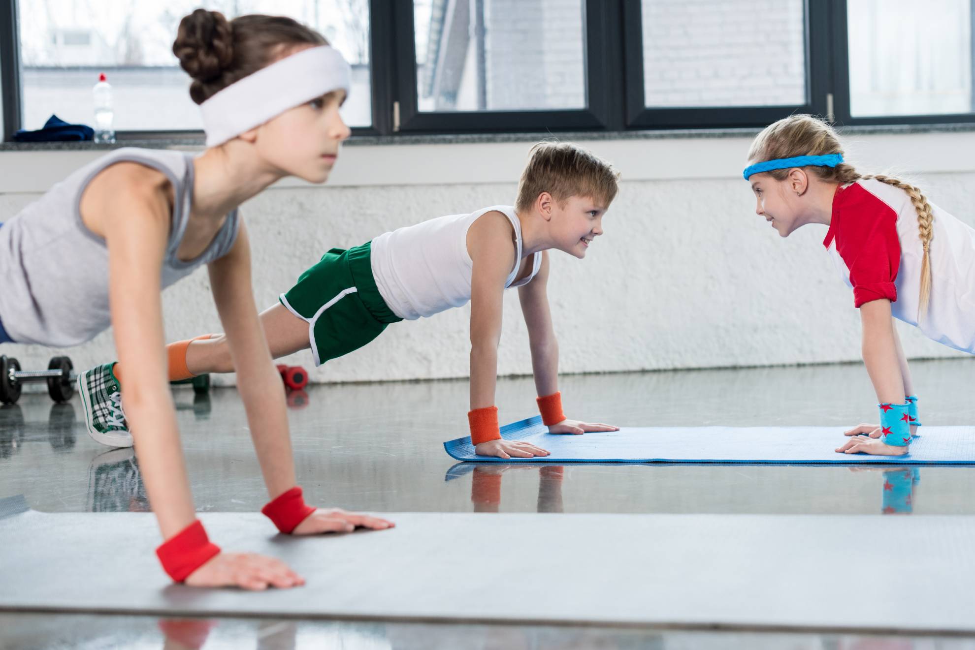 cute-sporty-kids-exercising-on-yoga-mats-in-gym-an-2021-08-29-10-47-54-utc (1)