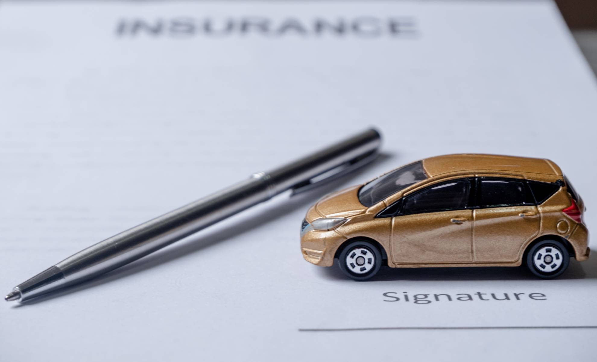 car-and-pen-on-insurance-documents-car-insurance-2021-12-04-17-33-13-utc (1)
