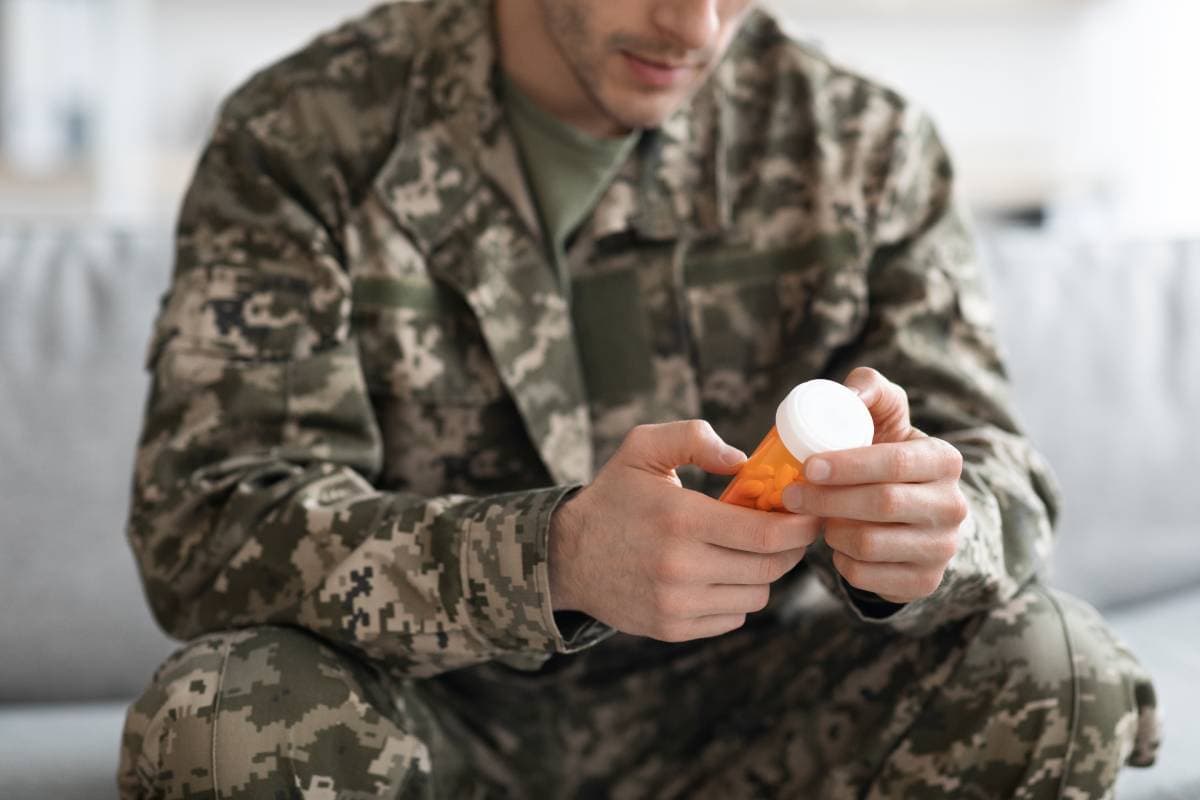 unrecognizable-soldier-holding-jar-with-medication-2022-12-16-06-52-57-utc (1) (1)