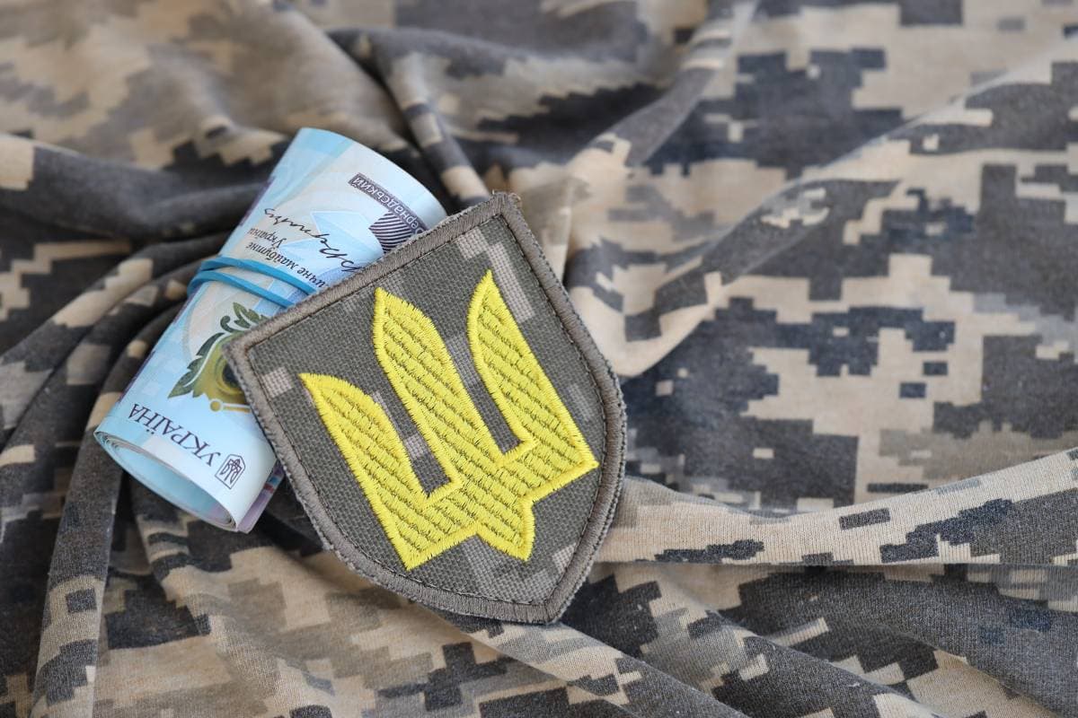 ukrainian-army-symbol-and-bunch-of-hryvnia-bills-o-2023-12-21-20-52-09-utc (1) (1)